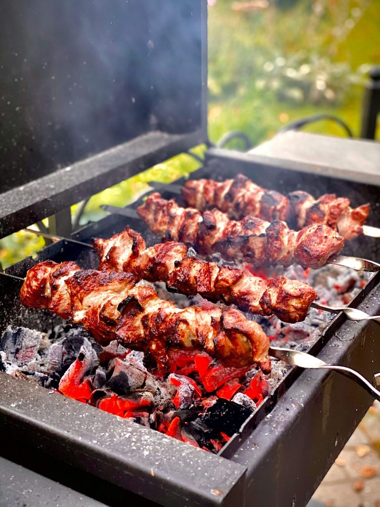 Saftige Fleischspieße brutzeln über offener Holzkohle bei einem Moskauer Grill im Freien.